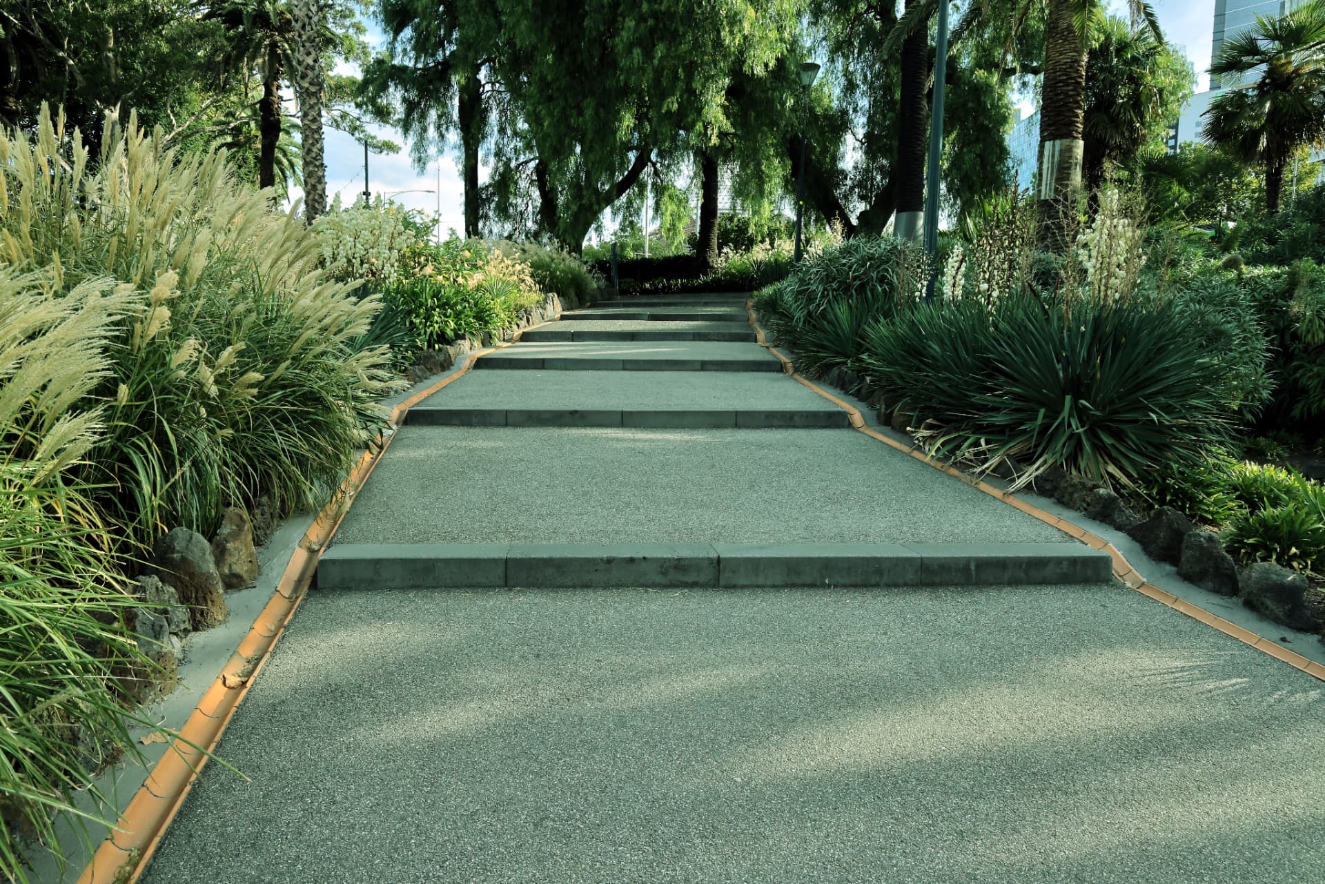 Resin bound stepped garden walkway with ornamental grasses and planting