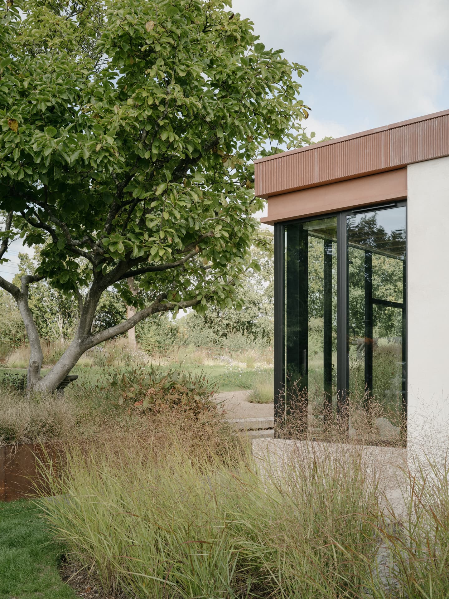 Naturalistic planting and grasses around a glazed garden room