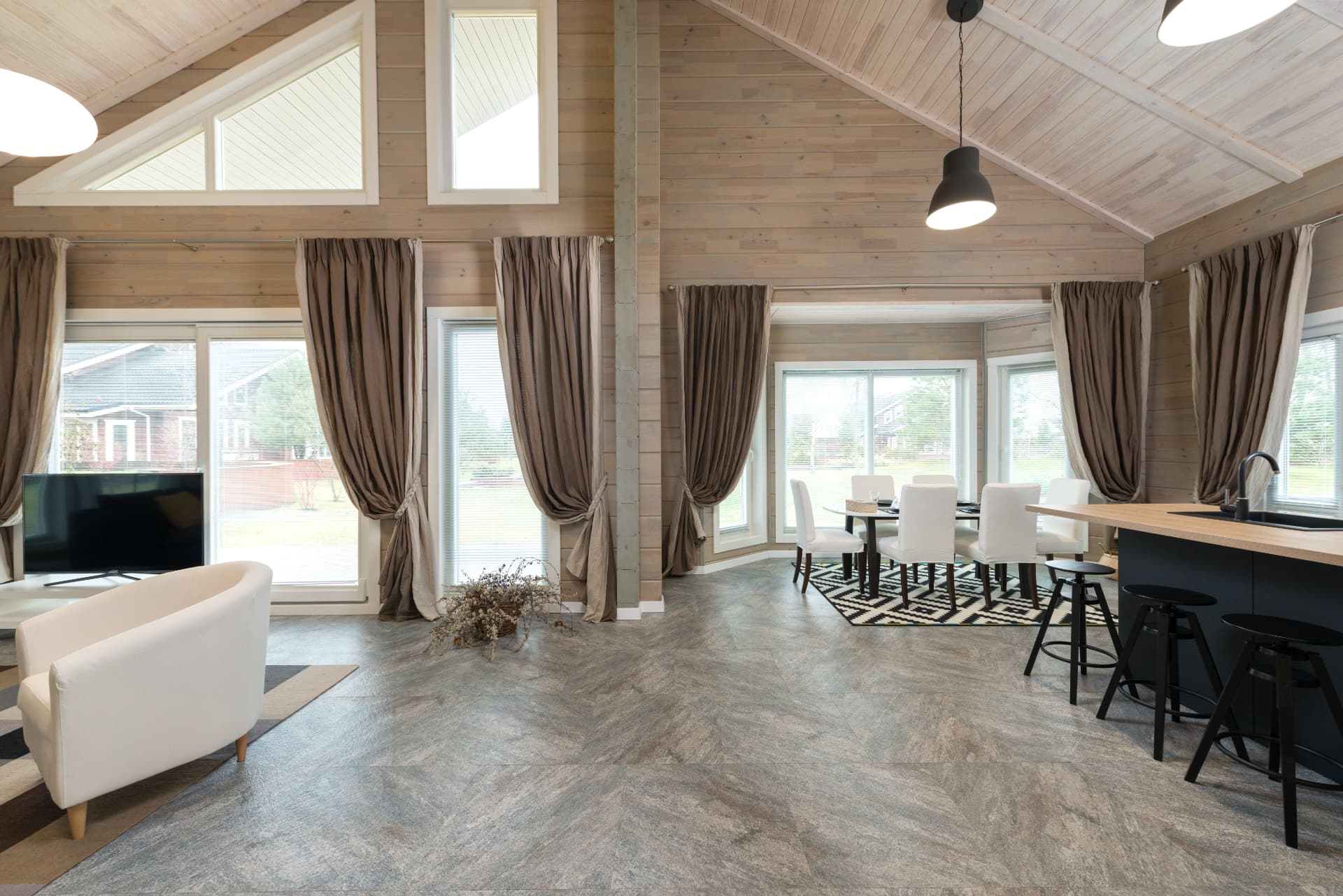 Vaulted open plan living and dining room with large format stone floor tiles