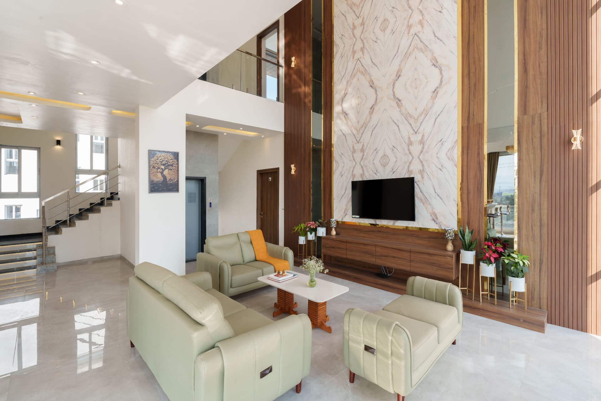 Double height living room with book-matched marble feature wall and walnut joinery