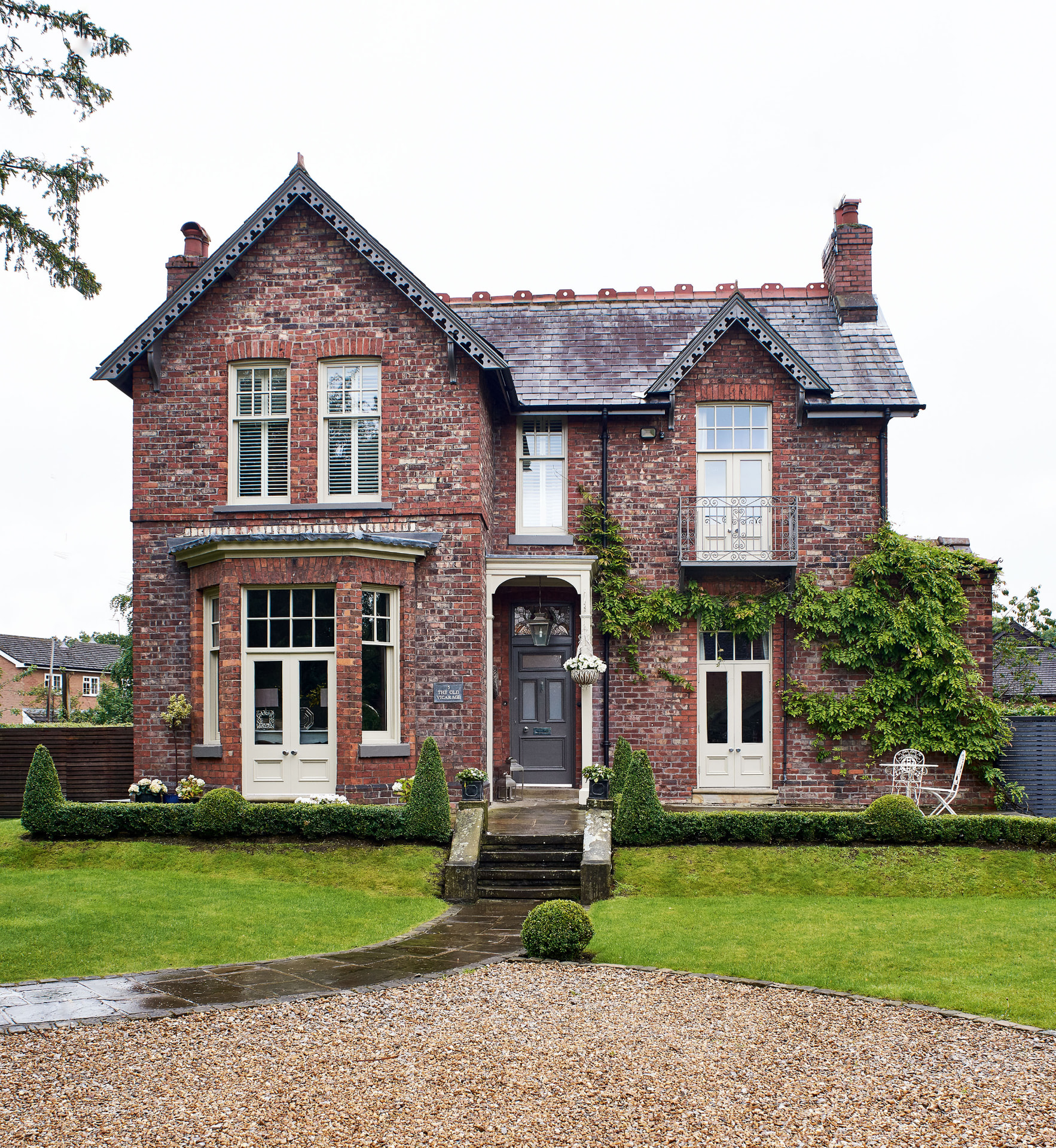 Victorian Villa — restored red brick facade with bay windows and formal front garden