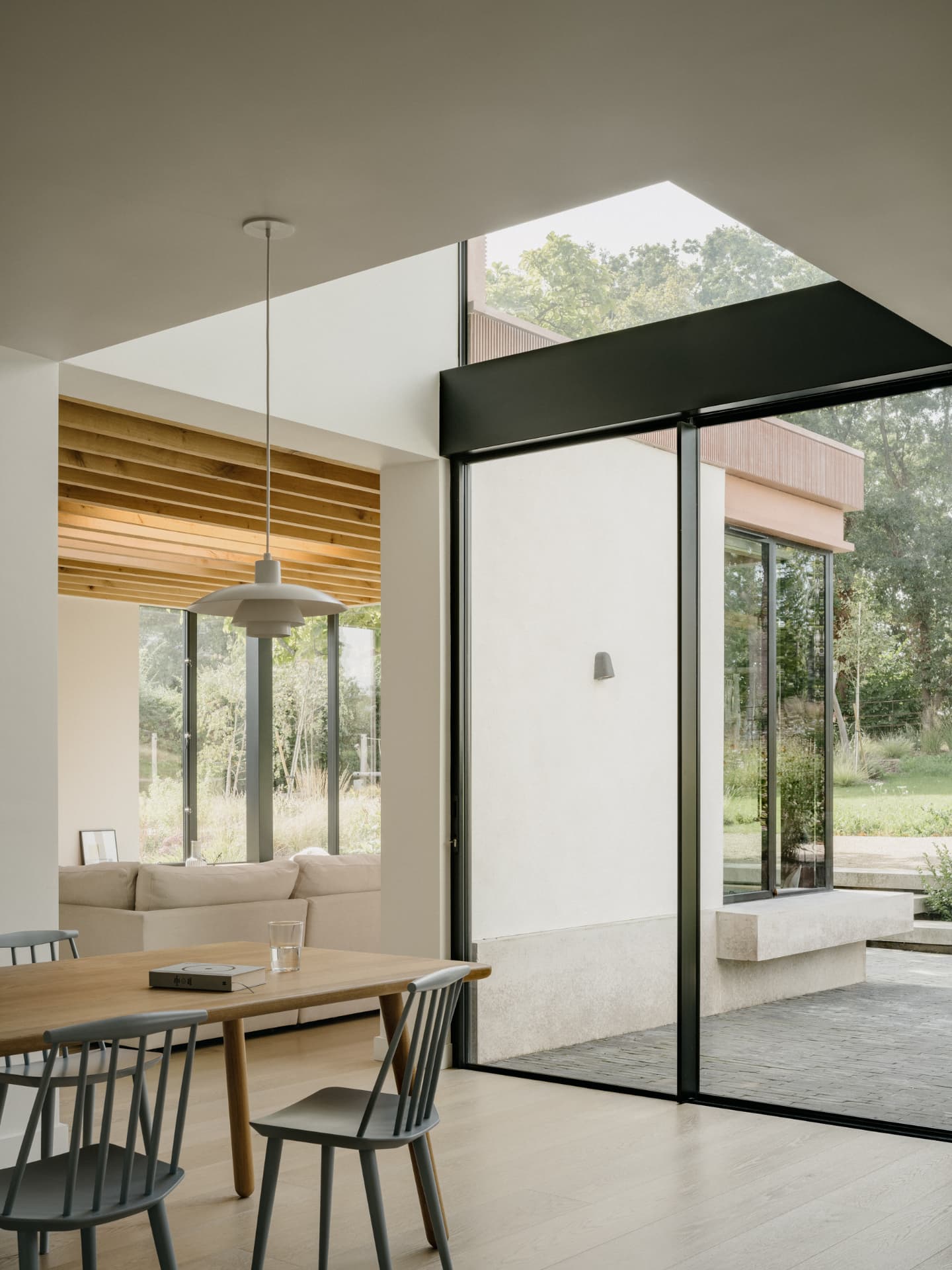 Contemporary rear extension interior with sliding glazing and oak slatted ceiling