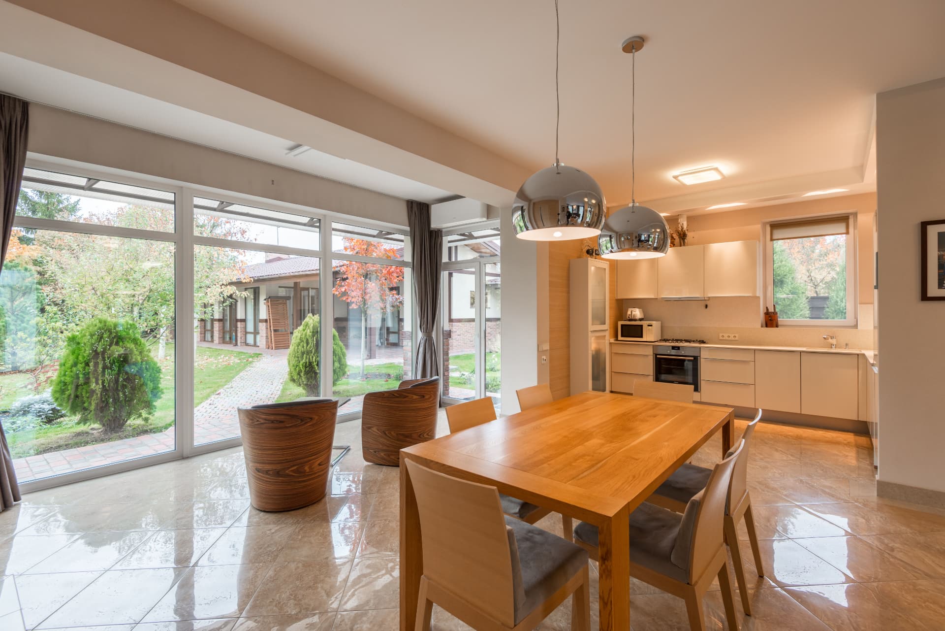 Garden room dining space with full height glazing and polished stone floor