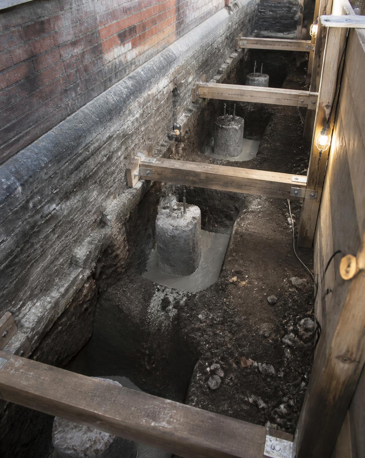 Underpinning pins cast beneath a Victorian brick foundation