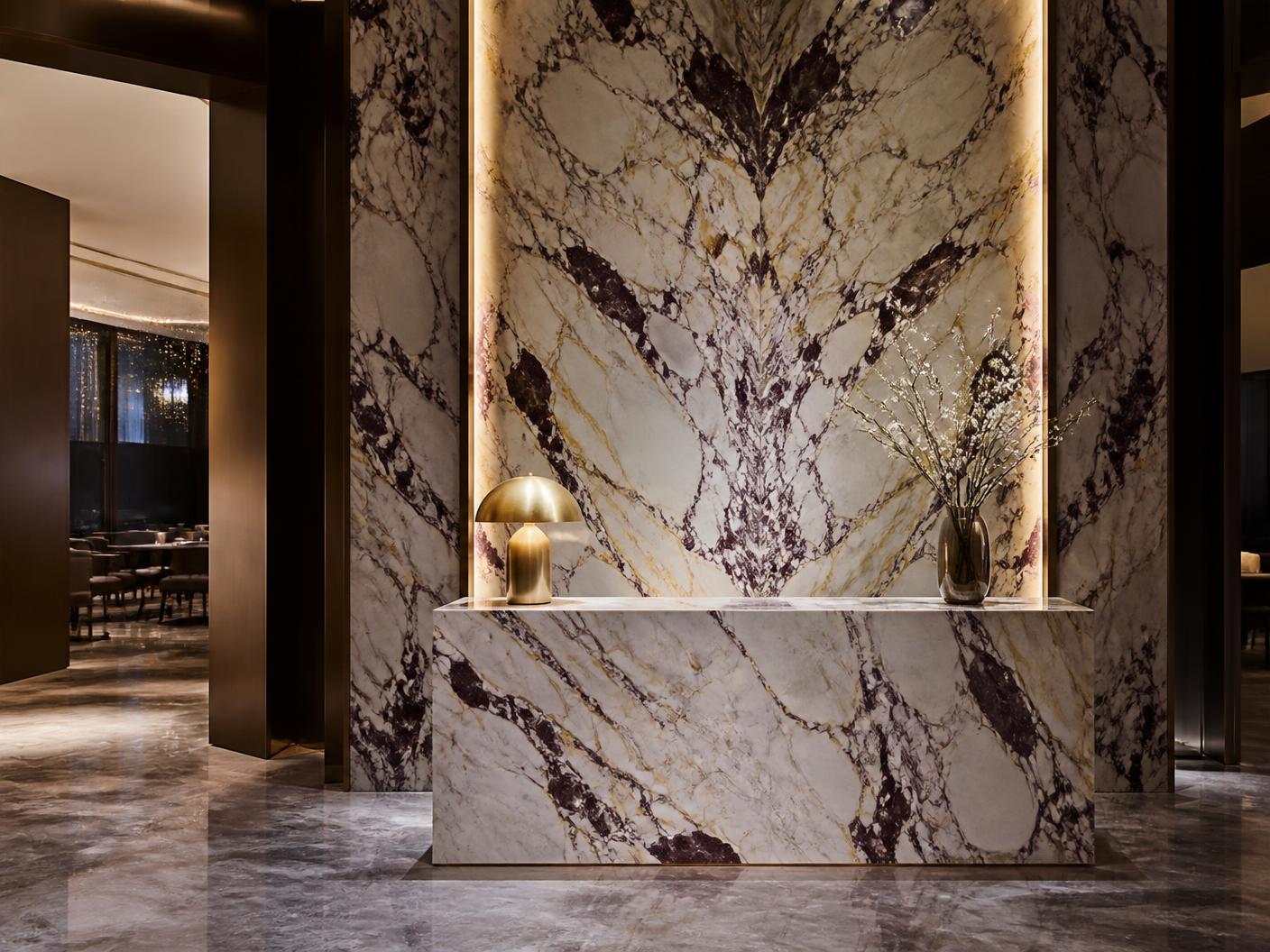 Calacatta Viola reception desk and lit stone panelling in Marylebone